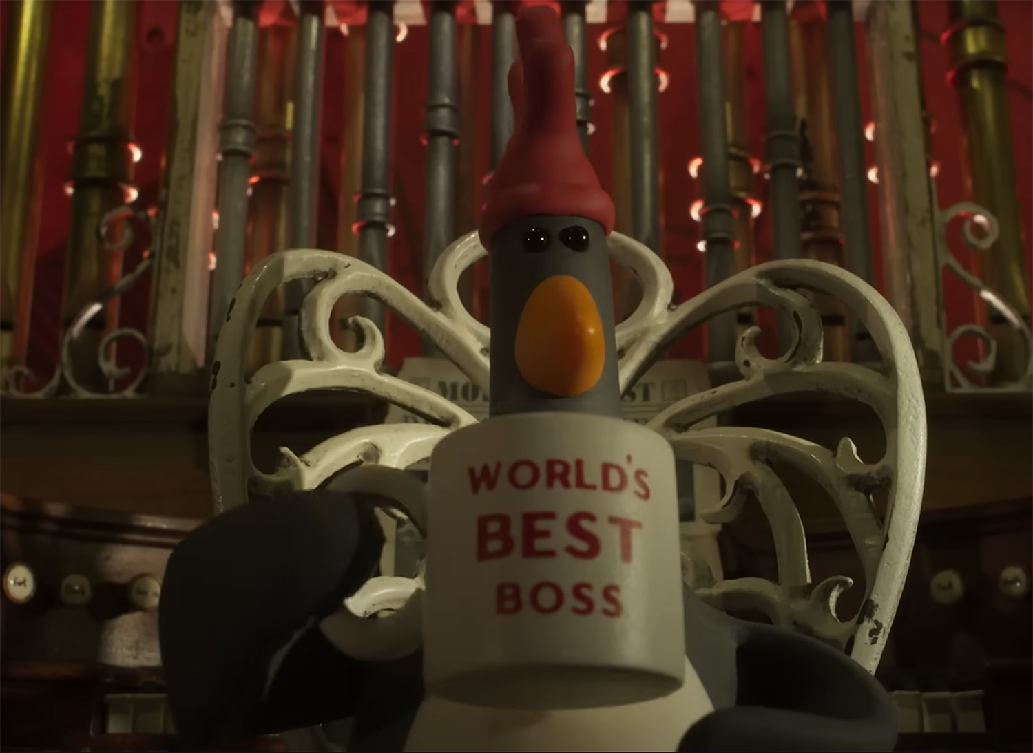 Feathers McGraw drinking out of a World's Best Boss mug.