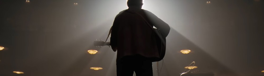 Bob black lit while playing the guitar.