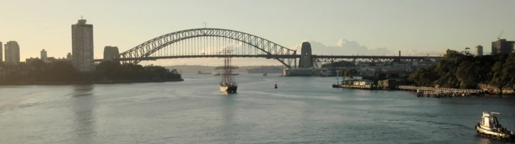 A Tall Ahip on Sydney Harbour with the Bridge in the background.