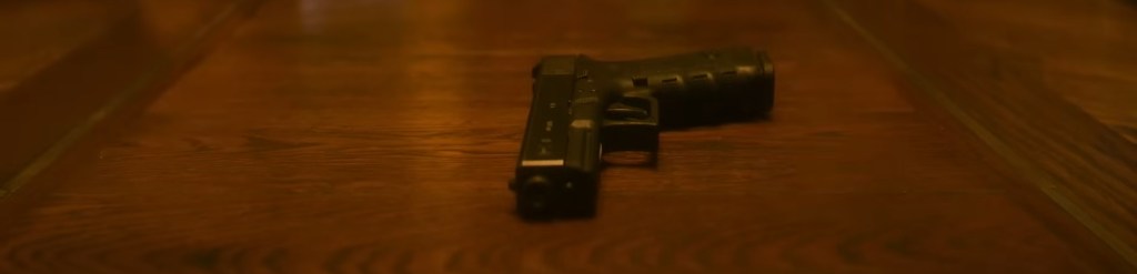 A handgun on a wooden table. 