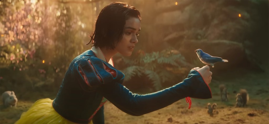 Snow White holds a bird on her finger. 