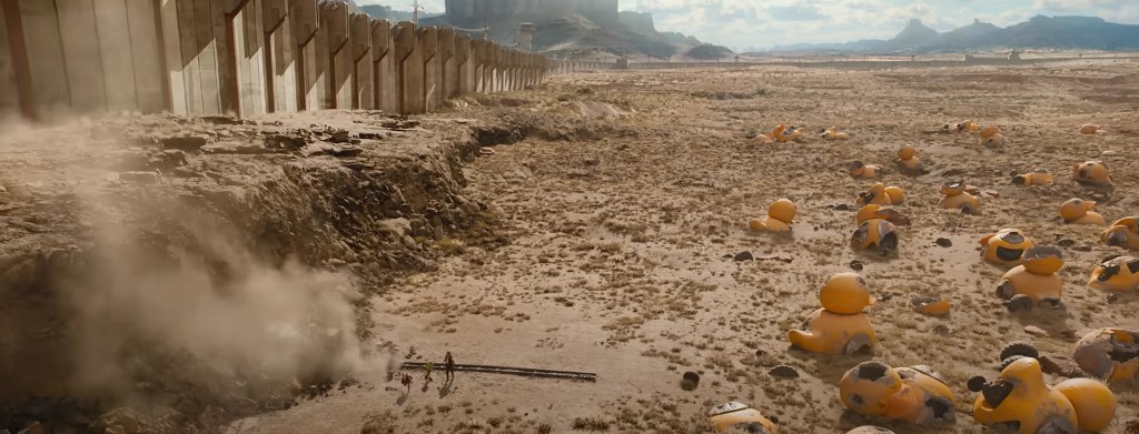 A wall, Hiding a desolate landscape full of robot corpses.