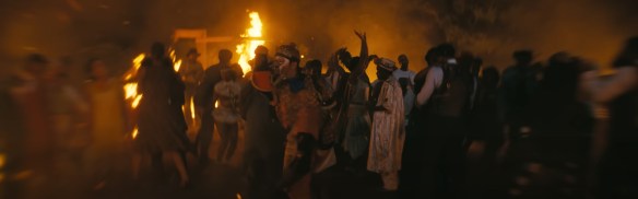 People dance in ecstasy as fire whips around them.