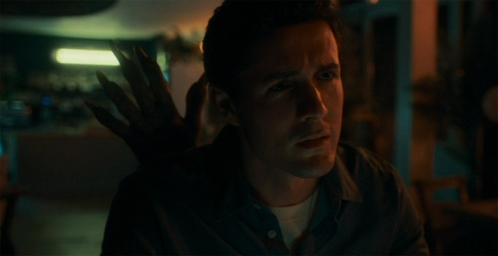 A monster hand appears behind Conrad.