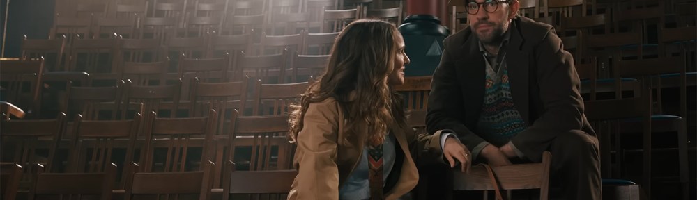 Brother and sister siting on some seats in an auditorium.