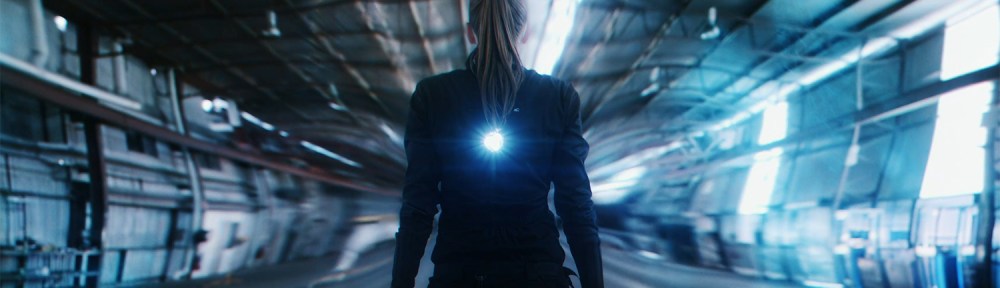 A woman stands as light and time bends around her.