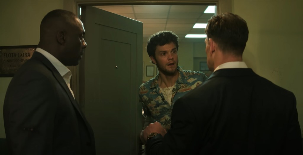 Jack Quaid pops out of a door. 