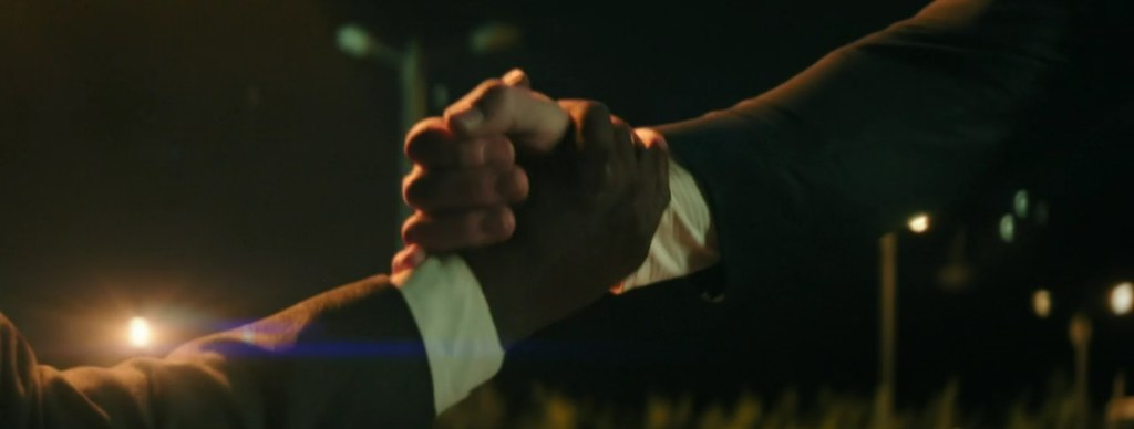 John Cena and Idris Elba hold hands.