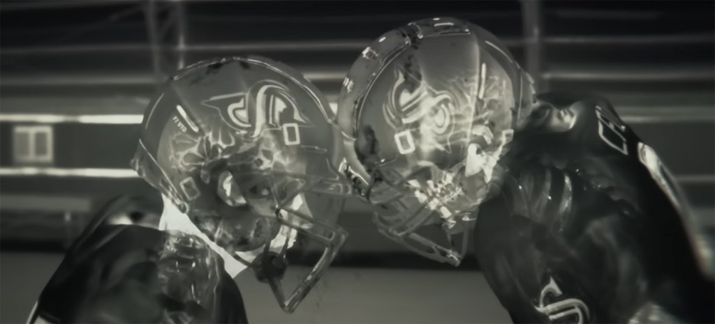 Two men in helmets crash into each other. 