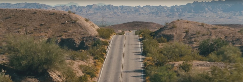 A road meandering up and down over some hills.