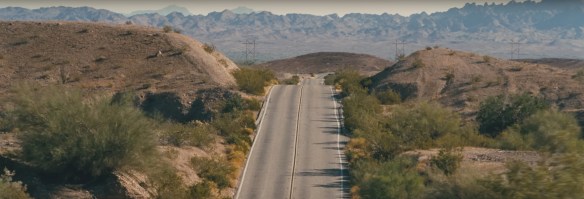 A road meandering up and down over some hills.