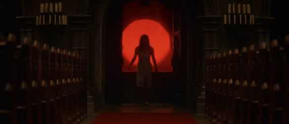 A woman bursts through the doors to a church.