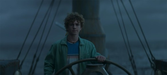Percy at the helm of a ship.
