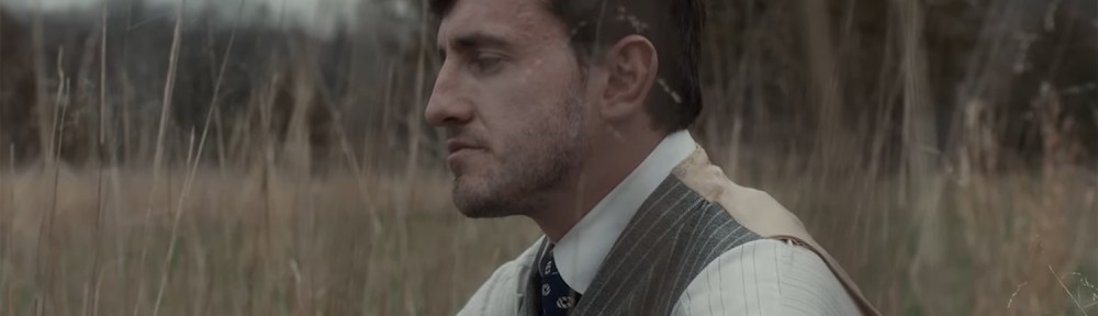 Paul Mescal sitting in a field.