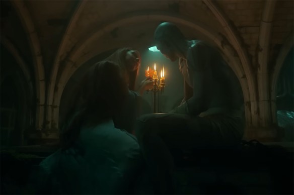 Jacob Elordi and Mia Goth under candlelight. 