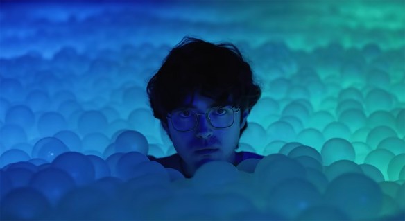 Dennis in an illuminated ball pit. 