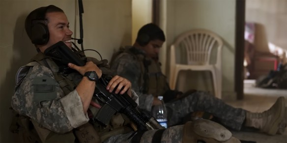 Soldiers sit and wait for the coming conflict.