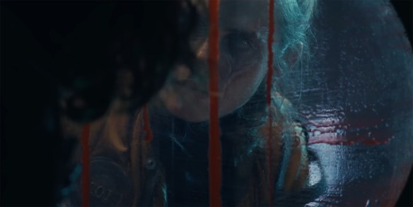 Simon looks out of a porthole as the blood streams down the window. 