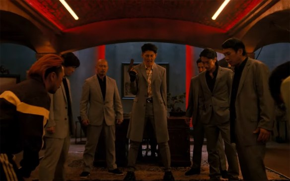 Yakuza henchmen yell support at their leader.