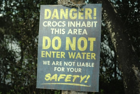"Danger! Crocs inhabit this area. DO NOT enter water. We are not Liable for your SAFETY!" sign.