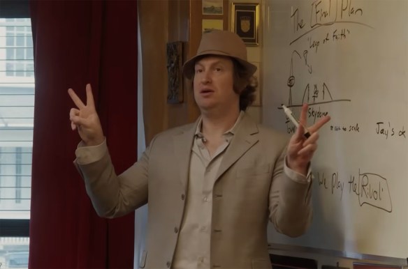A man stand in front of a whiteboard with a plan.