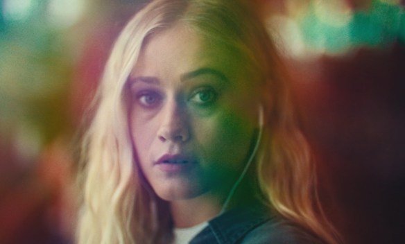 Olivia Taylor Dudley in a multi-coloured light almost like a kaleidoscope without the distortion. 