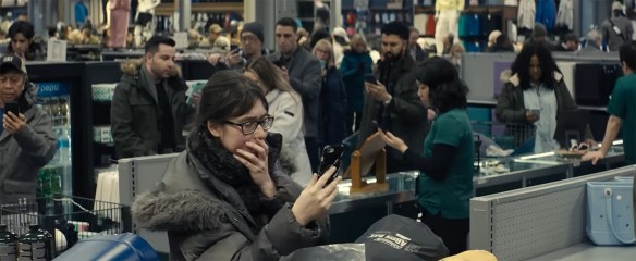Lots of people look on in horror at their phones. 