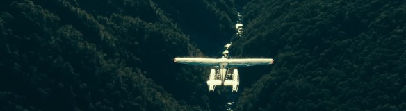 A plane flies low over a valley.
