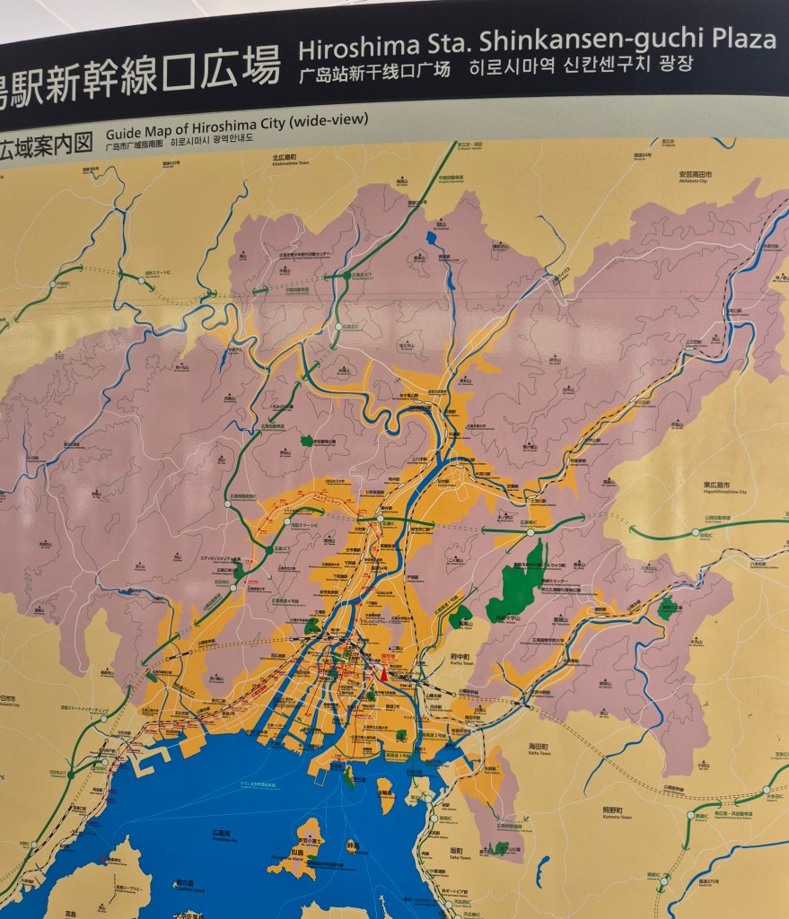 Map of Hiroshima City highlighting the Shinkansen-guchi Plaza area, featuring key landmarks, transportation routes, and topographical details.