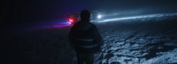 Bryan approaches a police car turned on its roof on snow.
