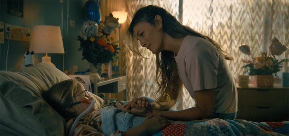 A mother comforts her daughter in the hospital. 
