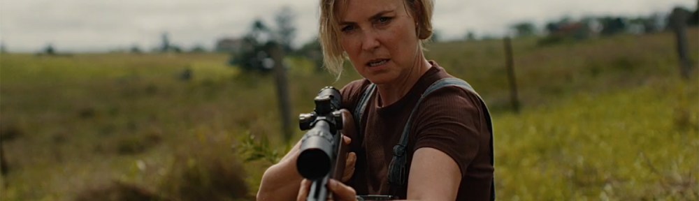 Radha Mitchell brandishing a rifle.