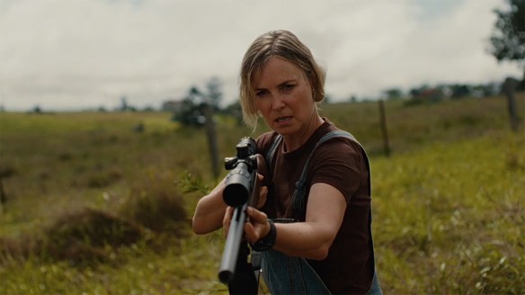 Radha Mitchell brandishing a rifle.
