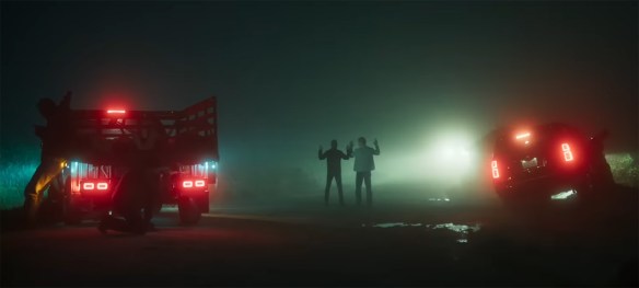 Two stand with their hands up. 