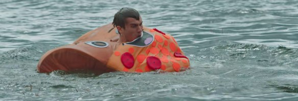 Luke Burke floating in a lake in a pizza mascot costume.