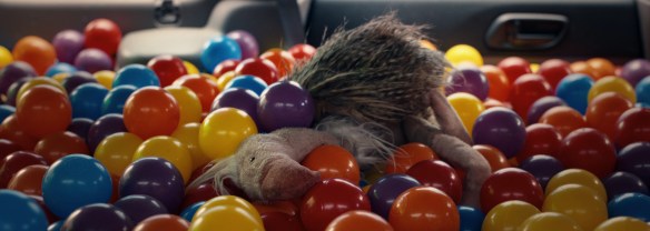A soft toy vulture on the top of a ball pit.